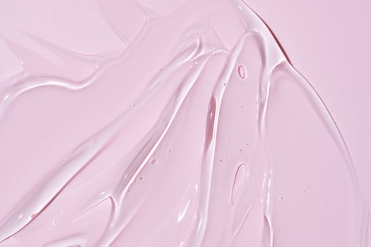 Liquid gel smear ion pink background. Beauty cosmetic smudge such as pure transparent aloe lotion, facial jelly serum, cleanser, shower gel or shampoo top view photo