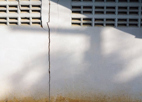 Cracks in the cement wall White cement of buildings damaged by earthquakes photo