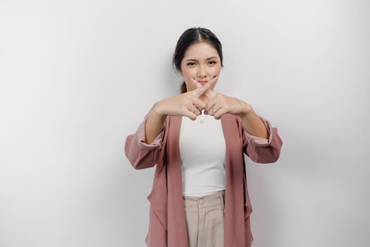 Beautiful Asian woman employee wearing cardigan with hand gesture pose rejection or prohibition with copy space photo