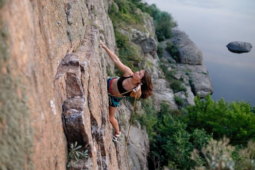 A girl climbs a rock. Woman engaged in extreme sport. photo