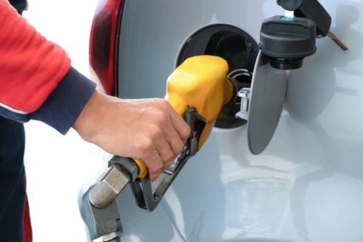 Refueling gun in the man's hand, while refueling car with gasoline fuel, at gas station concept of service and fuel. Closeup. photo