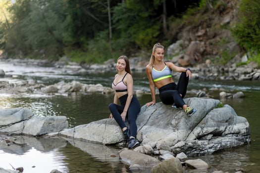 Happy female friends sitting in the meadows after a workout. photo