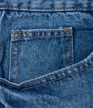 Blue jeans front pocket with buttons, close up photo