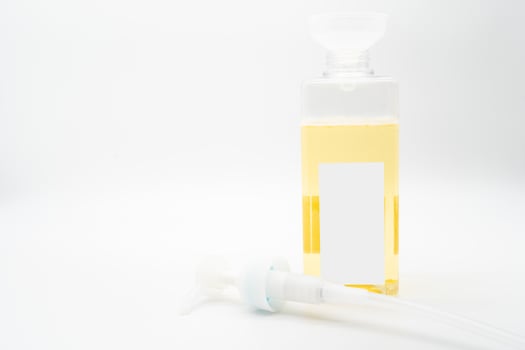 Pour yellow liquid through a funnel. Fill a dispenser with liquid soap or shampoo by pouring it from a refill to reduce plastic waste. Sustainable Zero Waste photo