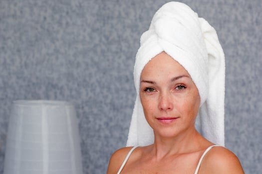 Portrait of caucasian middle aged woman of 40s with towel on head looking at camera photo