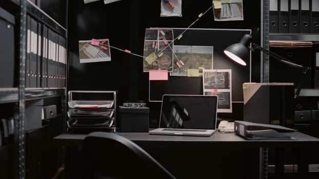 Empty incident room equipped with evidence board and clues on wall map, witness statements papers. Police archive office filled with case files and surveillance footage for investigation. photo