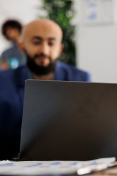 Arab company entrepreneur attending video call investor using laptop in busiess office. Executive manager discuss project strategy coworkers virtual meeting in coworking space photo