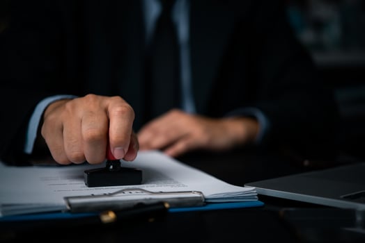 Authorized person rubber stamps contract certificates and office agreement documents. photo