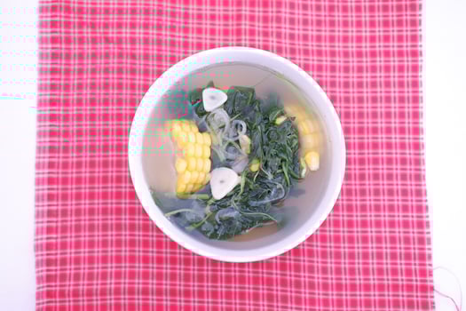 Sayur Bening Daun kelor jagung or Moringa Oleifera clear soup with sweet corn served in bowl photo