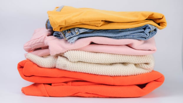 Piles of colorful clothes on white background. Clothes for donation or shopping. Household laundry. photo