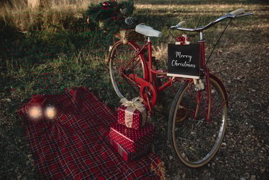 Red bicycle with Christmas gifts and some lanterns outdoors photo