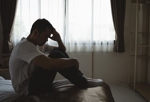 Silhouette depressed man sadly sitting on the bed in the bedroom. Sad asian men suffering depression insomnia awake and sit alone on the bed in bedroom. Depression health people concept. photo
