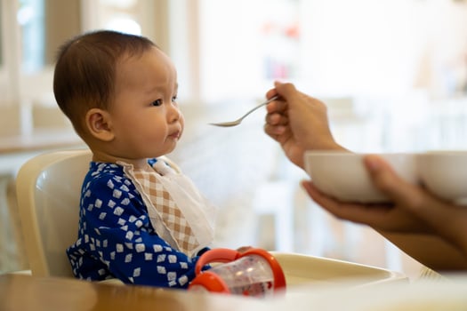 Babies are eating food in 6 month year olds photo