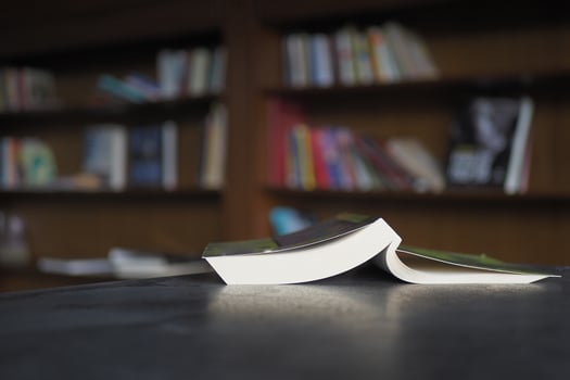 open book and a pencil on wooden table photo