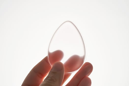 Silicone sponge for applying foundation in a woman's hand. photo