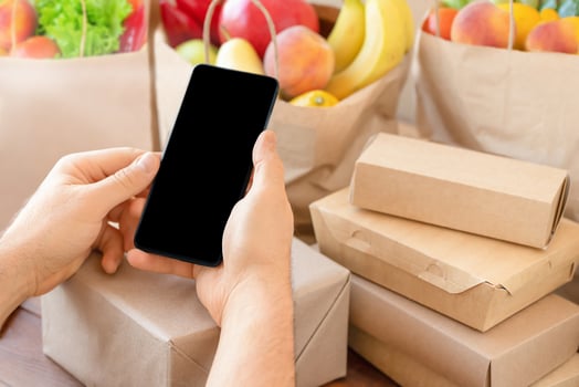 Phone in hands and food packaging photo