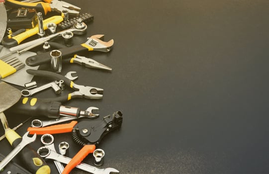 Handyman tool kit on black wooden table. Many wrenches and screwdrivers, pilers and other tools for any types of repair or construction works. Repairman tools photo