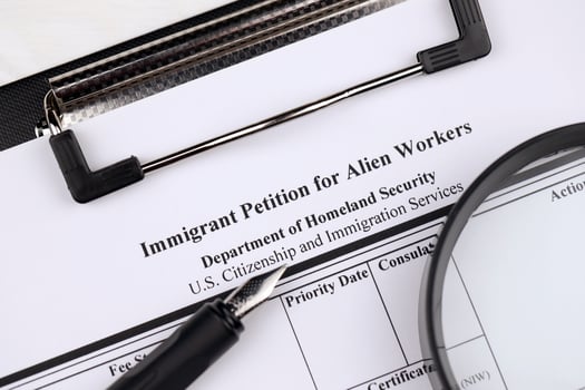 I-140 Immigrant petition for alien workers blank form on A4 tablet lies on office table with pen and magnifying glass photo