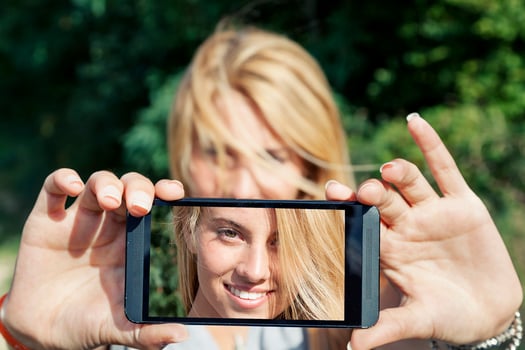 pretty woman with blond hair take a selfie with smart phone photo