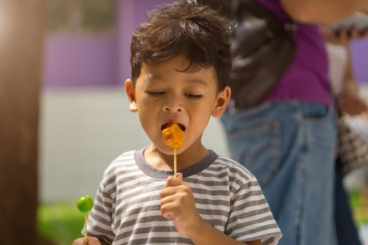 Asian boy eating a Ball plated dessert photo