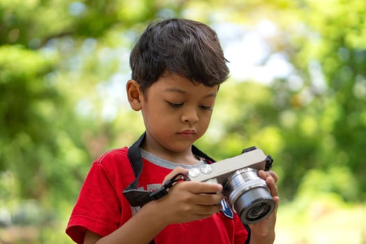 Asian kid use digital camera taking photo