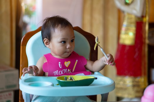 Asian baby girl 11 months year old is eating food. photo