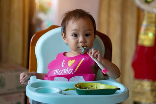 Asian baby girl 11 months year old is eating food. photo