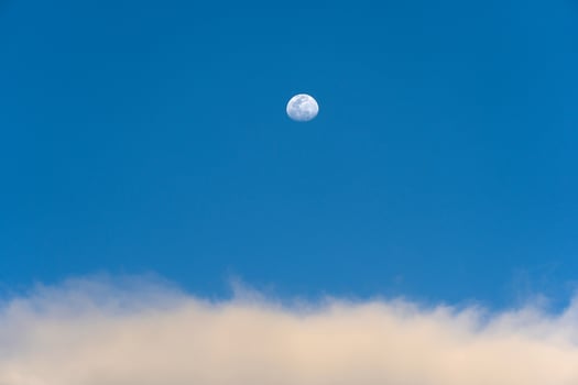Day moon and strange clouds on the sky photo