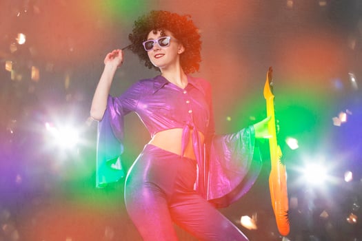 Happy girl pop singer with a toy guitar on the background of shiny confetti. Disco style. photo
