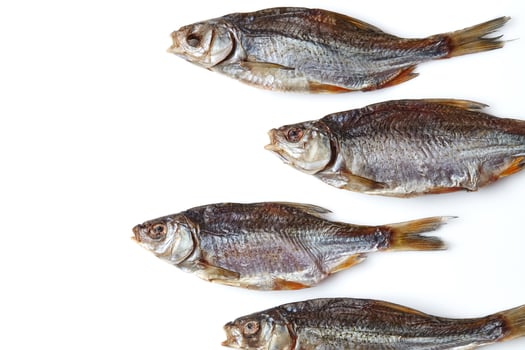 Dried or jerky salted roach, palatable clipfish isolated on white background. Salty beer appetizer. Traditional way of preserving fish. Close up photo
