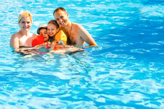 Young family, parents with children, in pool photo
