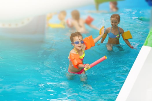 Cute toddler girl playing in swimming pool photo