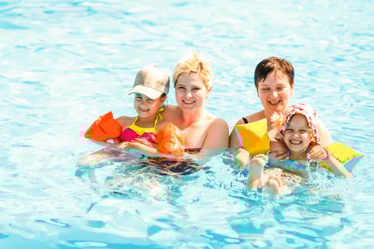 two women and their children in the pool photo