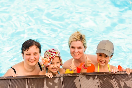 two women and their children in the pool photo