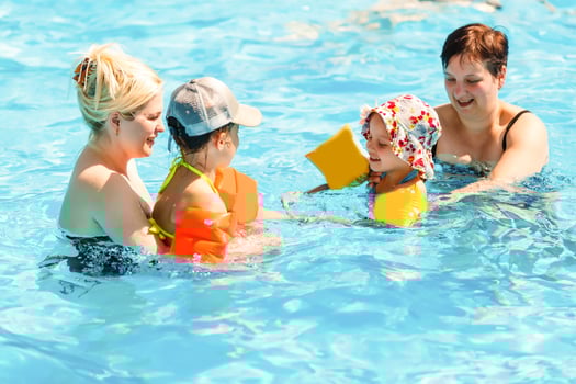 two women and their children in the pool photo