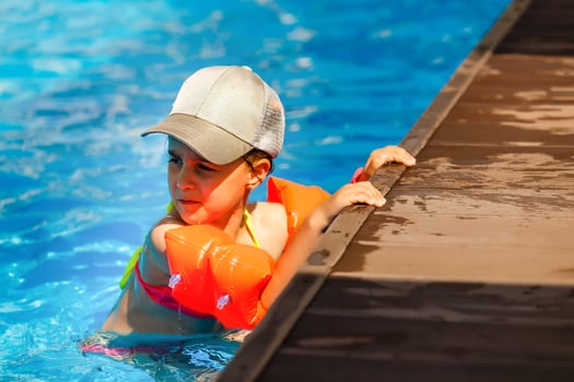 Cute toddler girl playing in swimming pool photo