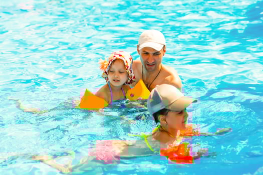 Father playing with his daughter in swimming pool photo