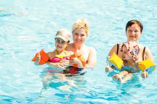 two women and their children in the pool photo