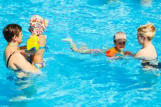 two women and their children in the pool photo