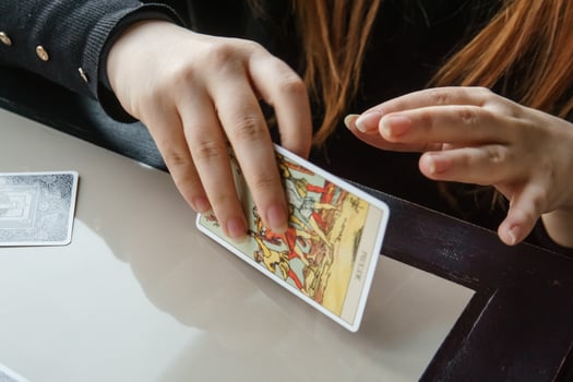 TVER, RUSSIA - FEBRUARY 11, 2023. Tarot cards, Tarot card divination, esoteric background. A woman makes a layout on the cards at the table. Divination, predictions on tarot cards. photo