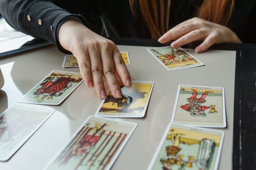 TVER, RUSSIA - FEBRUARY 11, 2023. Tarot cards, Tarot card divination, esoteric background. A woman makes a layout on the cards at the table. Divination, predictions on tarot cards. photo