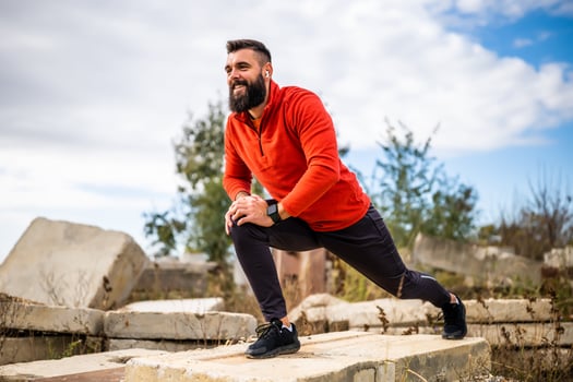 Adult man is exercising outdoor on sunny day. He is stretching his body. photo