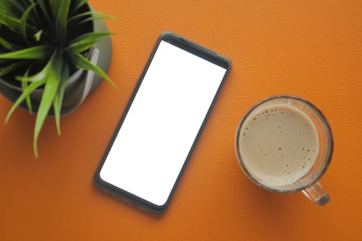 smart phone with empty white screen and cup of coffee on table photo