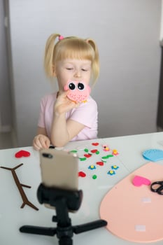 A blogger girl makes a felt craft for Valentine's Day in the shape of a heart. The concept of children's creativity and handmade. photo