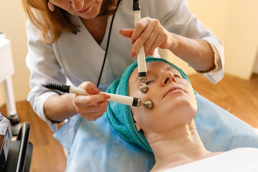 Cosmetologist makes the procedure microcurrent therapy in a beauty salon photo
