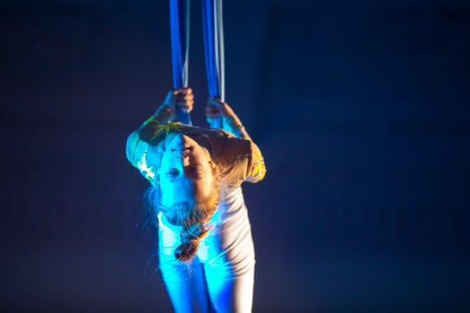 The girl performs acrobatic numbers on the canvases. A small circus artist performs on the canvases of acrobats. Child perform acrobatic elements in the air photo
