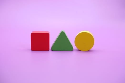 Set of colorful wooden shape toy. Square, triangle and round on Purple background photo