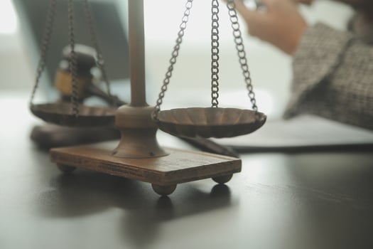 Business and lawyers discussing contract papers with brass scale on desk in office. Law, legal services, advice, justice and law concept picture with film grain effect photo