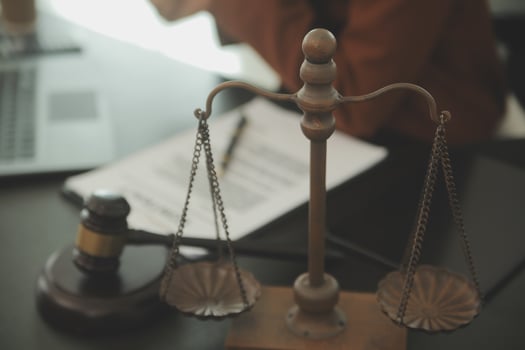 Business and lawyers discussing contract papers with brass scale on desk in office. Law, legal services, advice, justice and law concept picture with film grain effect photo