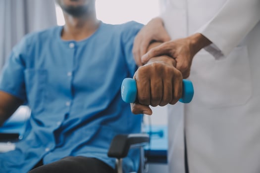 Physiotherapist man giving exercise with dumbbell treatment About Arm and Shoulder of athlete male patient Physical therapy concept photo